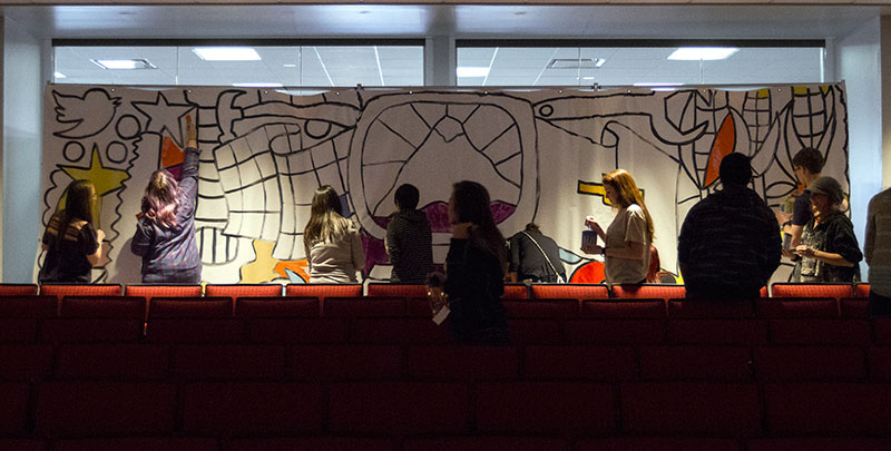IdeaFestival Bowling Green attendees paint a mural created by Andee Rudloff with items representing the day's speakers.