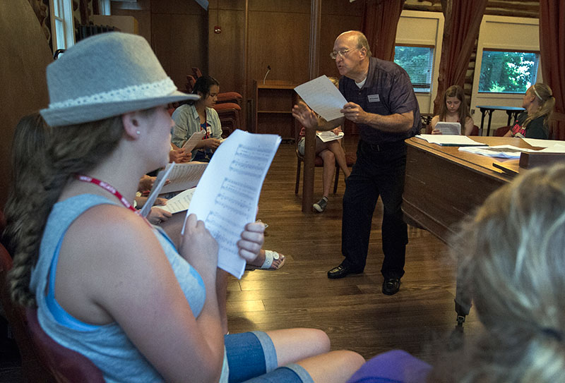 Jim Fulkerson directs his Musical Troupe class in singing "Supercalifragilisticexpialidocious" from "Mary Poppins" June 8 in the Faculty House. The class will perform a variety of Disney songs this year.  (photo by Sam Oldenburg)