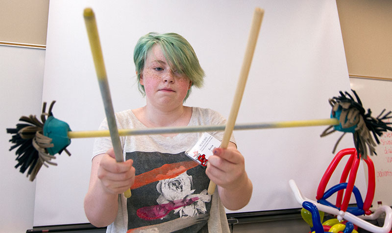 Evvie Cooley of Louisville practices tricks with devil's sticks during Clowning June 10. Evvie is taking Clowning for the second year. (Photo by Sam Oldenburg)