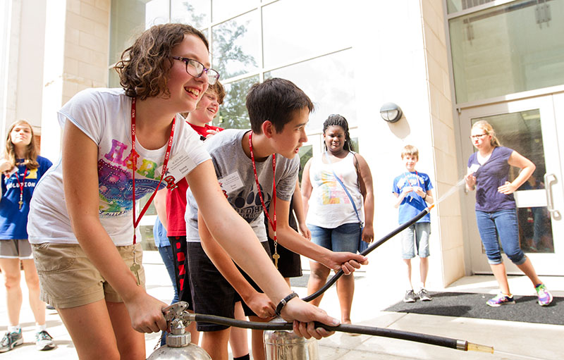 Emma Simpson (left) of Bowling Green sprays a water fire extinguisher during Chemistry of Everyday Wednesday, June 17. Emma's mother also attended SCATS when she was in middle school. (Photo by Sam Oldenburg)