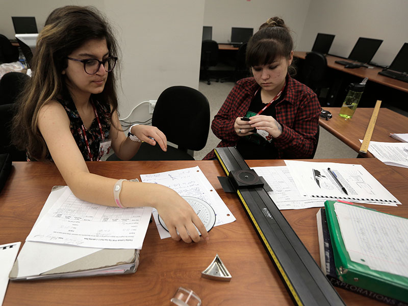 Muzna Jaafari of Saudi Arabia and group mate Lynn Perry of Cadiz, work together on a light refraction lab during Astronomy Tuesday, June 23.(Photo by Emilie Milcarek)