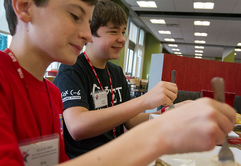 Campers Eric Eastman of Bowling Green (left) and Caleb Cummings of Imperial, Mo., eat breakfast with some of their hallmates Tuesday morning in Fresh Foods. (Photo by Sam Oldenburg)