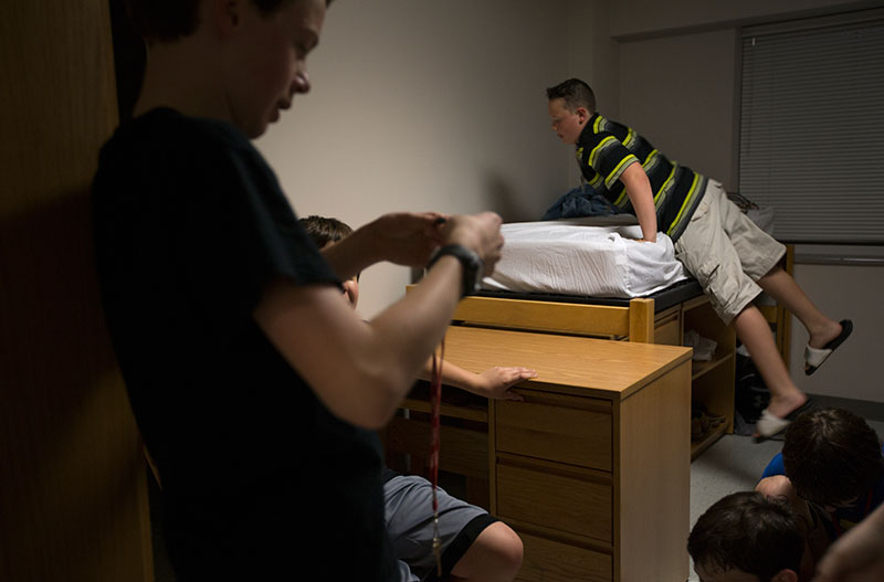 Cole LaDow of La Grange gets onto a bed while relaxing with hallmates before bedtime Tuesday. (Photo by Emilie Milcarek)