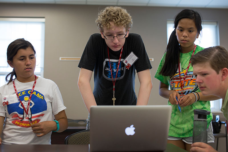 Claire Pinkston (from left) of Versailles, Lij Brazel of Louisville, Julia Howerton of Hanson, and Erik Bishop of Baxter, Tenn., read a prompt together before starting to work on speeches in Public Speaking Thursday, June 11. (Photo by Emilie Milcarek)