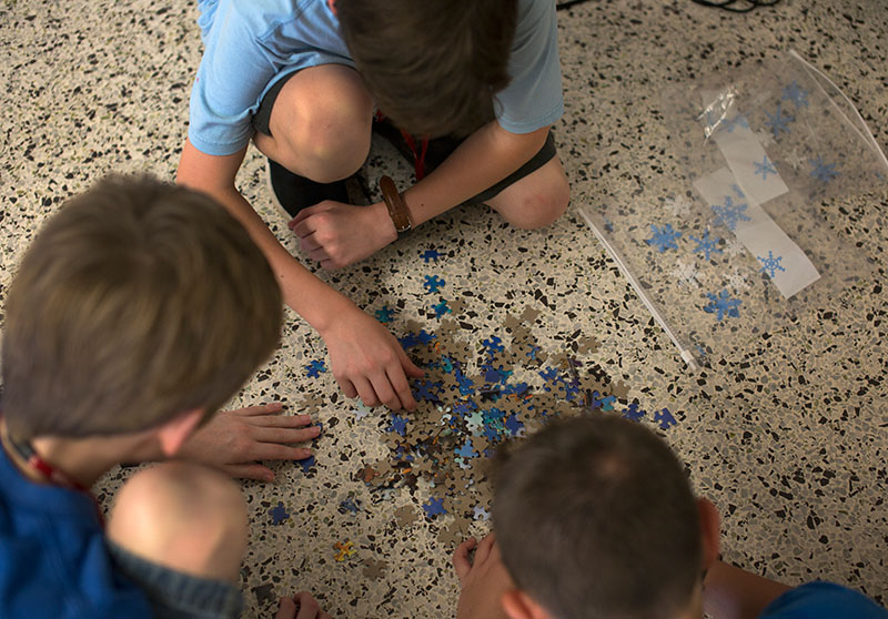 Three SCATS campers from Team Albania put a puzzle together during the one of the competitive events in the SCATS Olympics Saturday, June 13. (Photo by Emilie Milcarek)