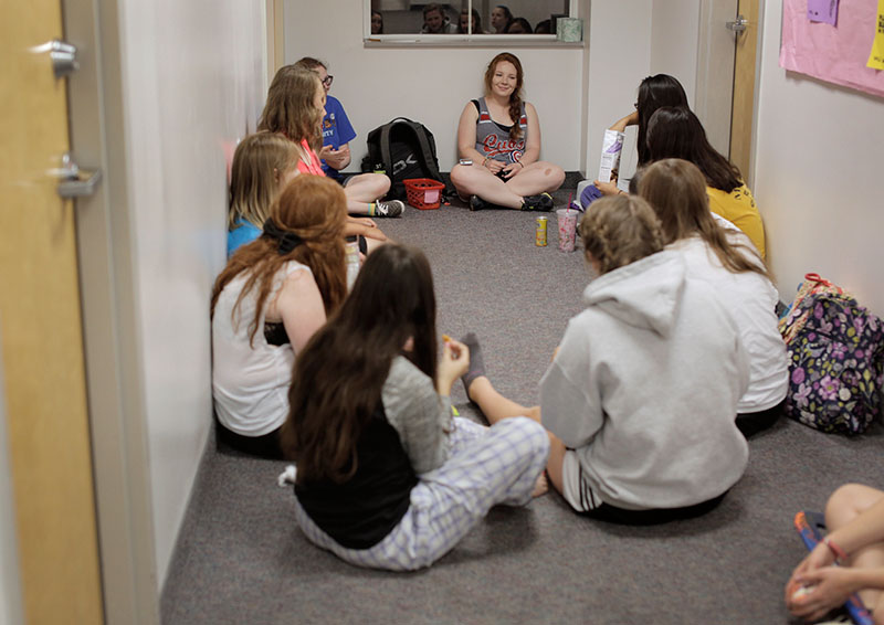 Counselor Courtney George chats with her campers during hall time Wednesday, June 24. The girls shared stories and bonded before going to their rooms for the night. (Photo by Emilie Milcarek)