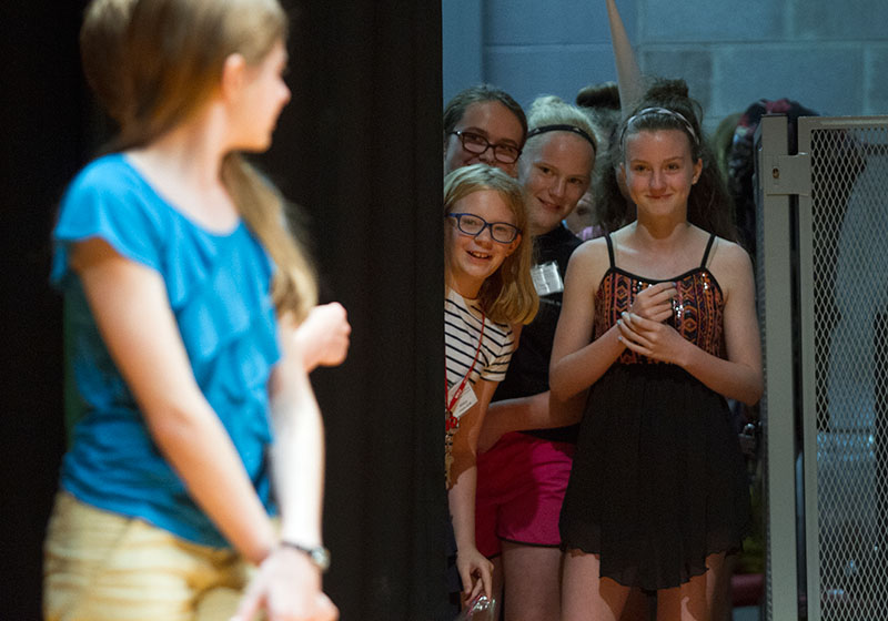 Abby Adams-Smith (from left) of Bowling Green, Chloe Paddack from Falls of Rough, Cassidy Burnside of Vallonia, Ind., and Emma North of Owensboro watch an introduction presented by the emcees before their group's performance in the SCATS Talent Show Wednesday, June 17. (Photo by Sam Oldenburg)