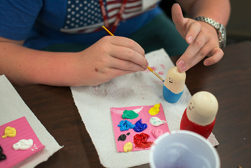 Sebastian Brightwell of Louisville paints a Matryoshka doll in Discovering Russia on Thursday, June 18. (Photo by Emilie Milcarek)