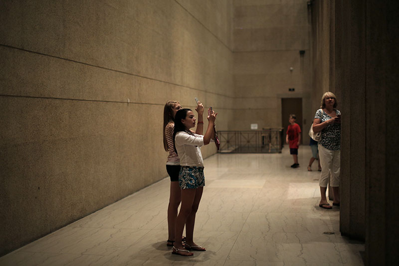 Melina Durham and Savanna Simons, both of London, take photos of the Athena statue that reaches to the top of the ceiling inside the Nashville Parthenon while on a Humanities field trip Thursday, June 25. (Photo by Emilie Milcarek)