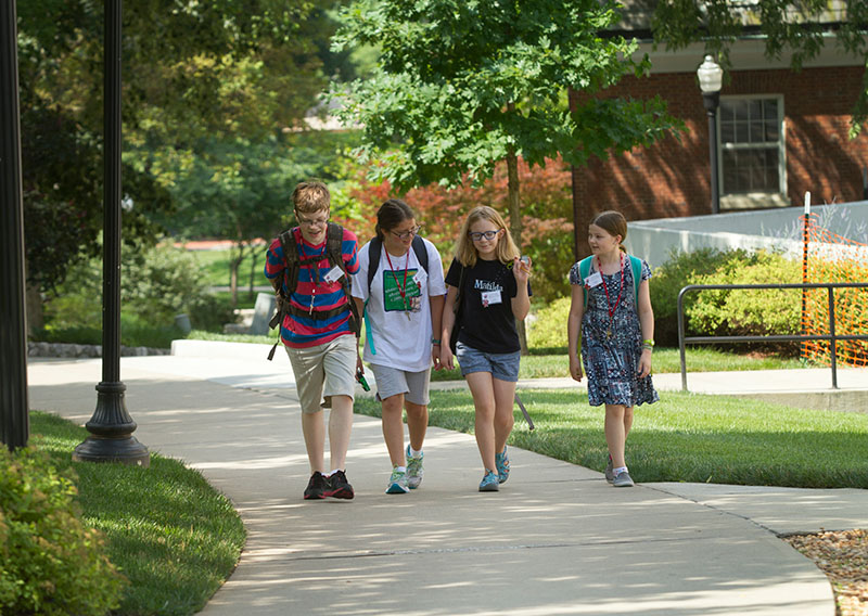 Griffin Salsman (from left) of Springfield, Tenn., Kathleen Alcock of Cleveland, Tenn., Abby Adams-Smith of Bowling Green and Audrey Thacker of Louisville walk up the hill together during a class change Friday, June 12. (Photo by Sam Oldenburg)
