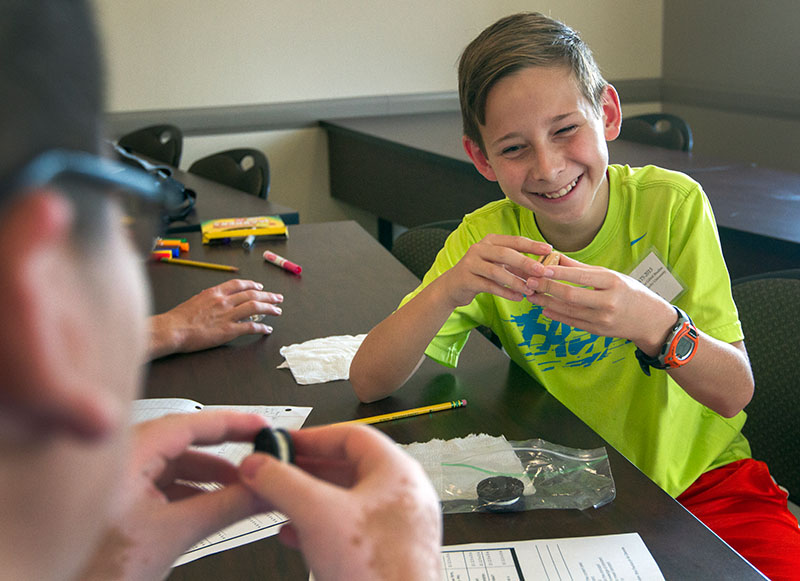Ari Brelig of Bonnieville laughs as his partner, Javier Sierra of Bowling Green, instructs him on how to eat on Oreo as part of an activity in Public Speaking Tuesday, June 9. (Photo by Sam Oldenburg)