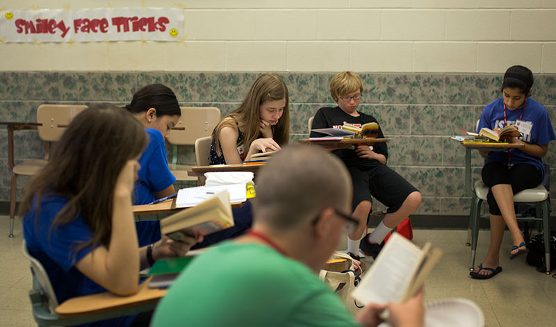 Kennedy Pendleton (center) of Hopkinsville and other campers read "The Transal Saga" during Be a Writer Monday, June 8. (Photo by Emilie Milcarek)