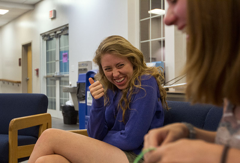 Counselors Ellie Hogg (left) and Emily Powell share a laugh Friday night, June 5, in the lobby of Northeast Hall. Counselors spent the evening bonding and making door decorations. (Photo by Sam Oldenburg)