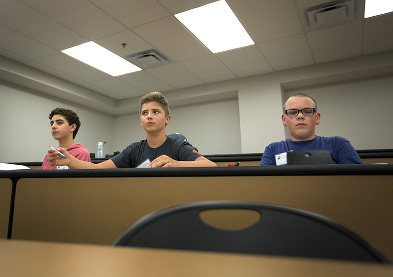 Students Declan Delaney (left), Graham Stephens (middle), and Noah Helphenstine (right) join in on the class discussion about which dragon belongs in which scenario and why during Dragons, Chemistry, Science, and the Hobbit Tuesday, June 9. (Photo by Emilie Milcarek)