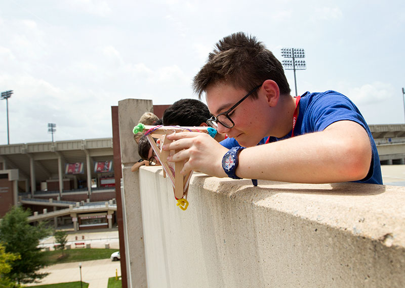Lorenzo Mahoney of Prospect aims his egg drop container before letting it go from atop Parking Structure 2 Tuesday, June 23, during Problems You Have Never Solved Before.  (Photo by Sam Oldenburg)