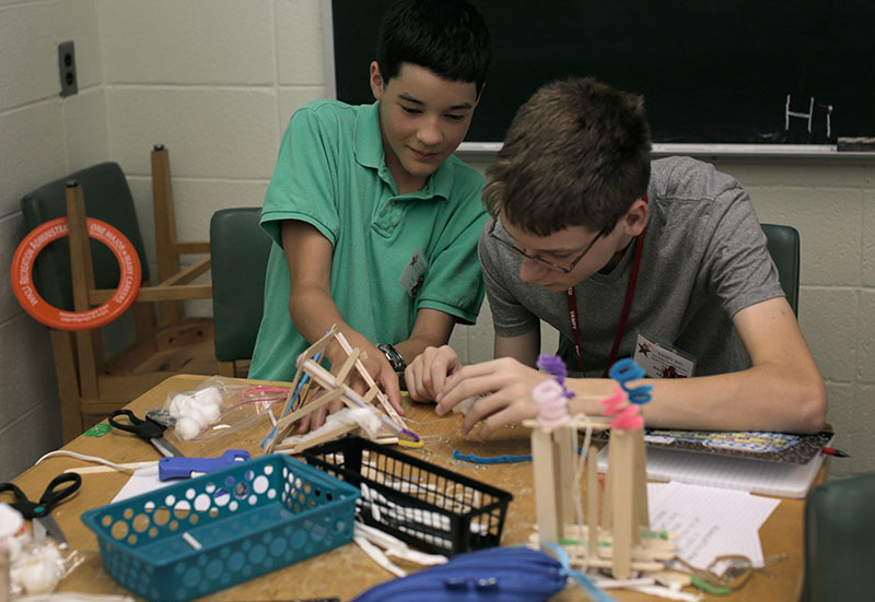 Kevin Swanger (left) of Louisville, Tennessee, and his partner, Andrew Reese of Lexington, build a contraption to house their egg for an egg drop experiment in Problems You Have Never Solved before on Tuesday, June 23. (Photo by Emilie Milcarek)