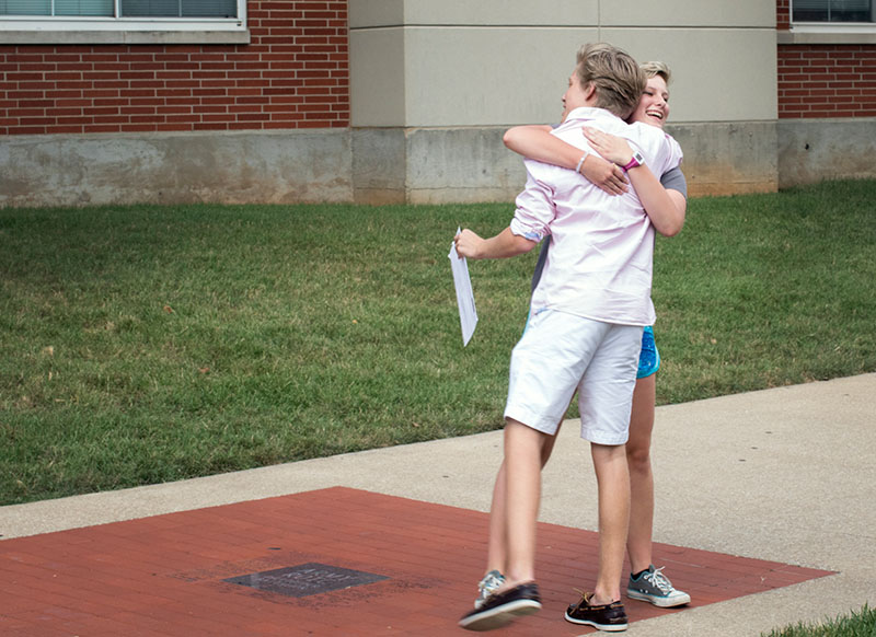 Returning campers Brock McDaniel (left) of Corydon and Annie Miller of Owensboro greet each other with a hug during VAMPY check in Sunday, June 21. (Photo by Emilie Milcarek)