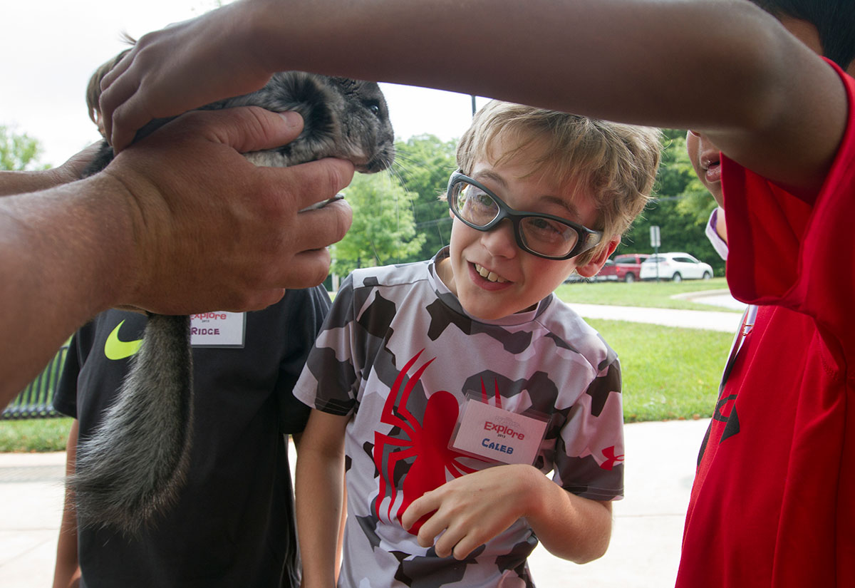 Caleb watches a chinchilla as a fellow camper pets it during a presentation from Zoodles during Camp Explore Monday, July 6. (Photo by Sam Oldenburg)