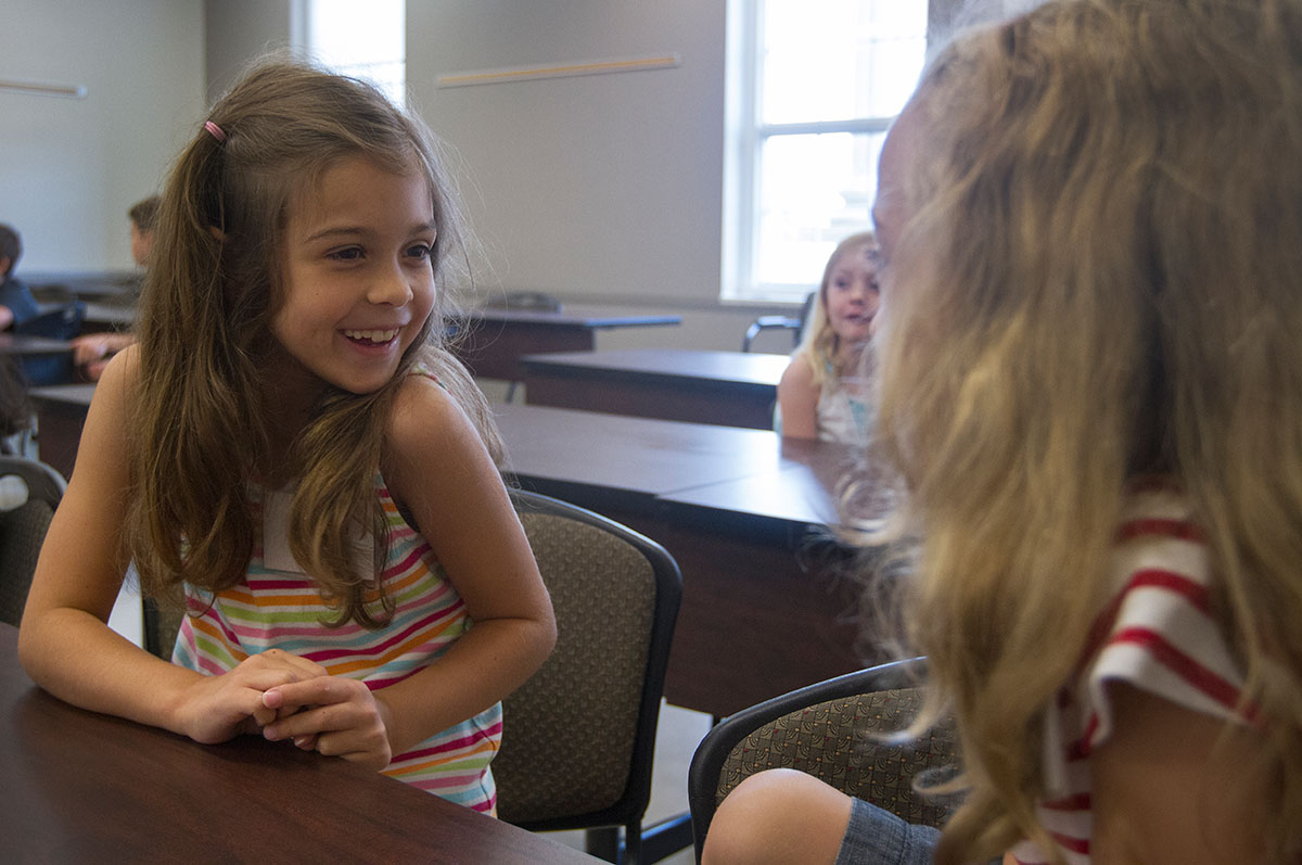 Claire (left) chats with Chloe in between activities in Science Monday, July 6, during Camp Explore. (Photo by Sam Oldenburg)