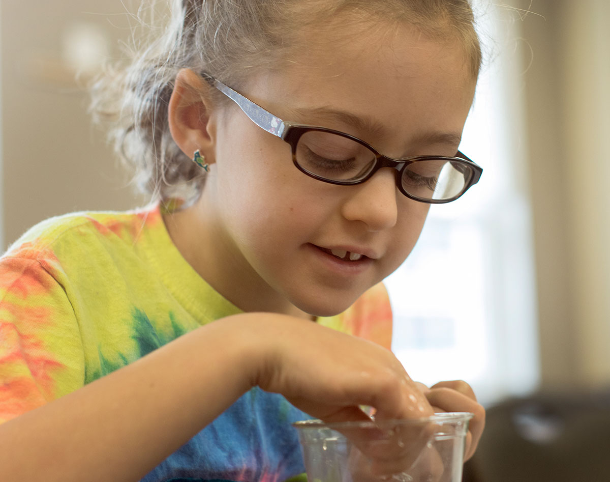 Savannah tries to figure out how to make a paperclip float in Science during Camp Explore Monday, June 6. (Photo by Emilie Milcarek)