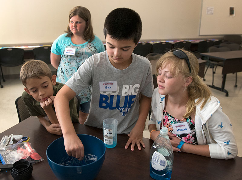 Ben stirs soap and corn syrup to make homemade bubbles as his classmates watch in Math on Tuesday, June 30, during Camp Innovate. (Photo by Emilie Milcarek)