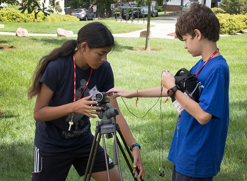 Adrienne Sato (left) and Conor Green, both of Louisville, set up their camera and audio equipment before filming their next scene in their class, Teenagers On Film,  Thursday, July 2. (Photo by Emilie Milcarek)