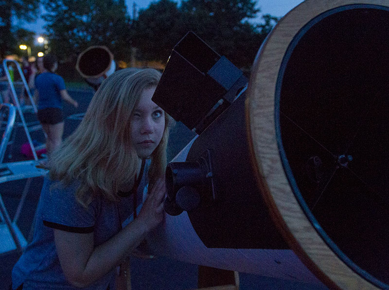 Hannah Butler of Elizabethtown looks through the spotting scope to line up a telescope before a stargazing party Monday, July 6. Astronomy students were trained to use the telescopes and operate them before other campers arrived. (Photo by Sam Oldenburg)