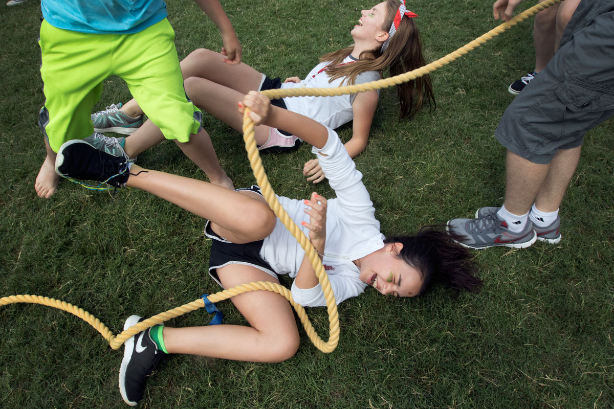 Melina Durham (front) and teammate Lauren Simmons, both of London, fall to the ground after their team won the first round of tug--of-war during the VAMPY Olympics Saturday, June 27.  (Photo by Emilie Milcarek)