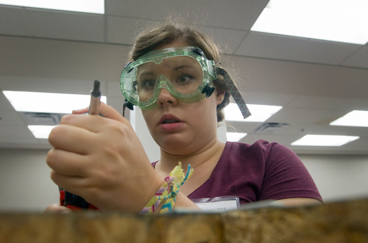 VAMPY camper Olivia Gilliam of Madisonville prepares her screwdriver to attach two boards to be used for a Rube Goldberg machine in STEAM Labs Friday, July 3. (Photo by Sam Oldenburg)