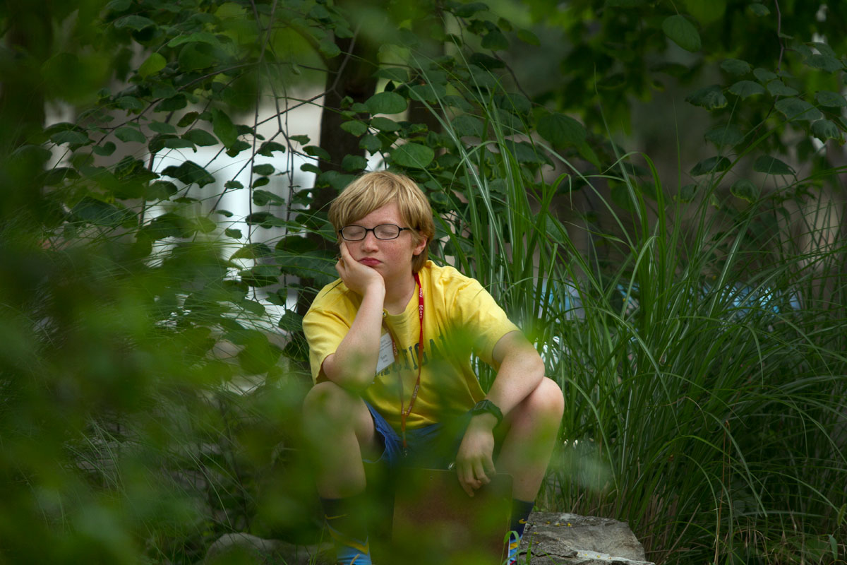SCATS camper Sam Frey of Louisville listens to his surroundings as part of an observational poetry exercise in Be A Writer Thursday, June 18. (Photo by Sam Oldenburg)