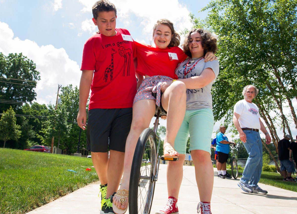 Sophie Lawrence of Georgetown rides a unicycle with help from Dawson Wilcox (left) of Fort Payne, Ala., and Margot Hare of Morehead Monday, June 15, during Clowning. SCATS Clowning students took turns attempting to ride the unicycle and spotting each other. (Photo by Sam Oldenburg)