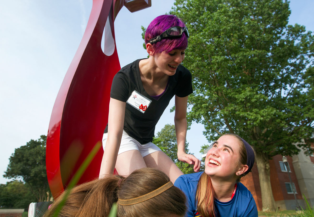 VAMPY campers Samantha Fagone (top) of Louisville and Laina Caywood of Georgetown share a laugh while making a human pyramid at Centennial Mall during the Extreme Campus Tour optional Monday, June 22. (Photo by Sam Oldenburg)