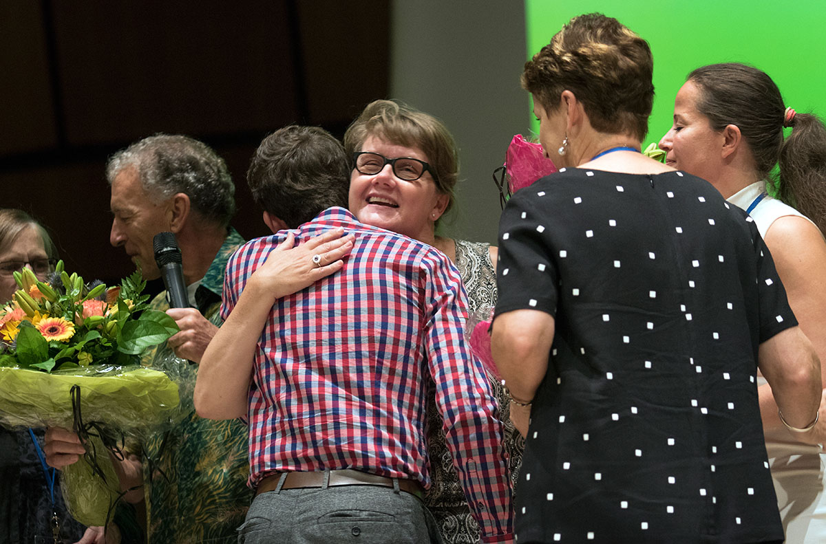 Local conference committee member Susanne Hoff-Clausen hugs Executive Administrator Tyler Clark during the closing ceremony of the World Conference.