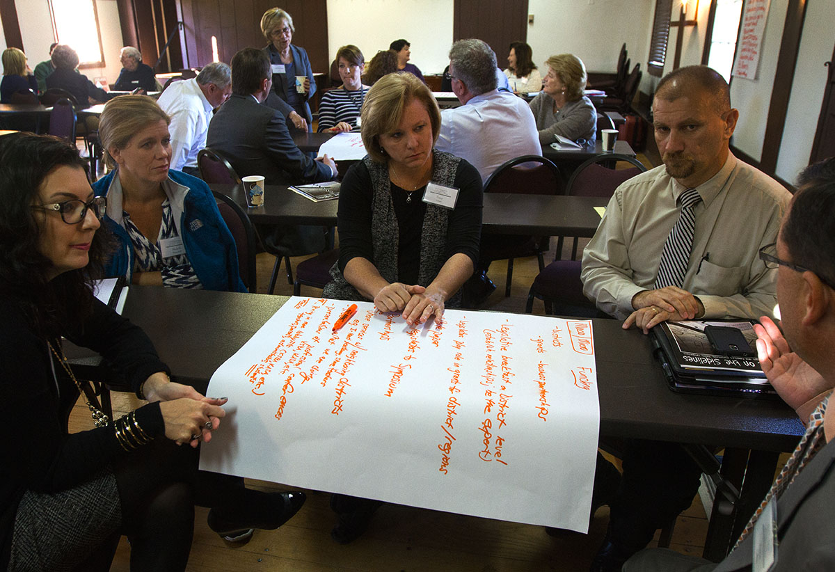 Symposium participants discuss common barriers to gifted education in small groups October 14.