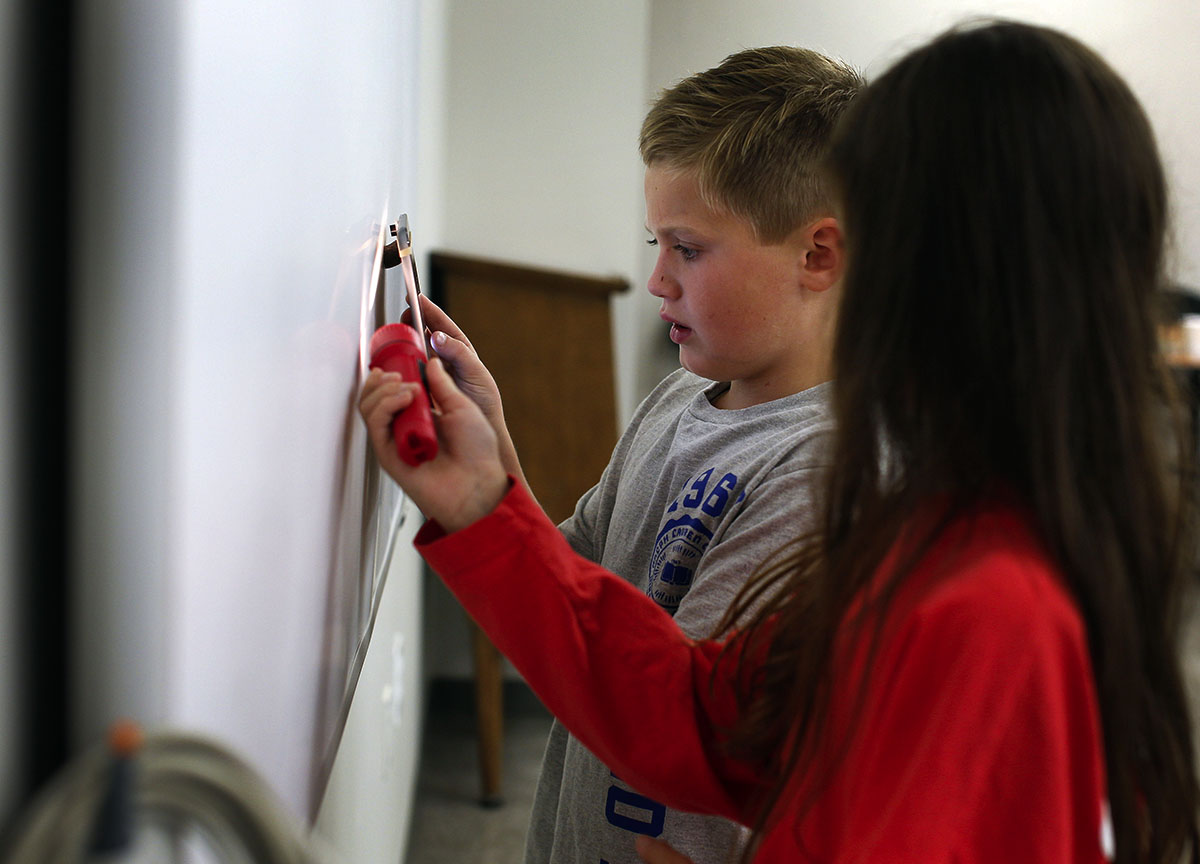 Zeke Stumbo, 8, of Bowling Green and his partner Alex Doig, 10, of  Scottsville, use their new macro lens they attached to their iPad to find different patterns around the classroom during iPad iExplorations on Saturday, October 31. (Photo by Emilie Milcarek)