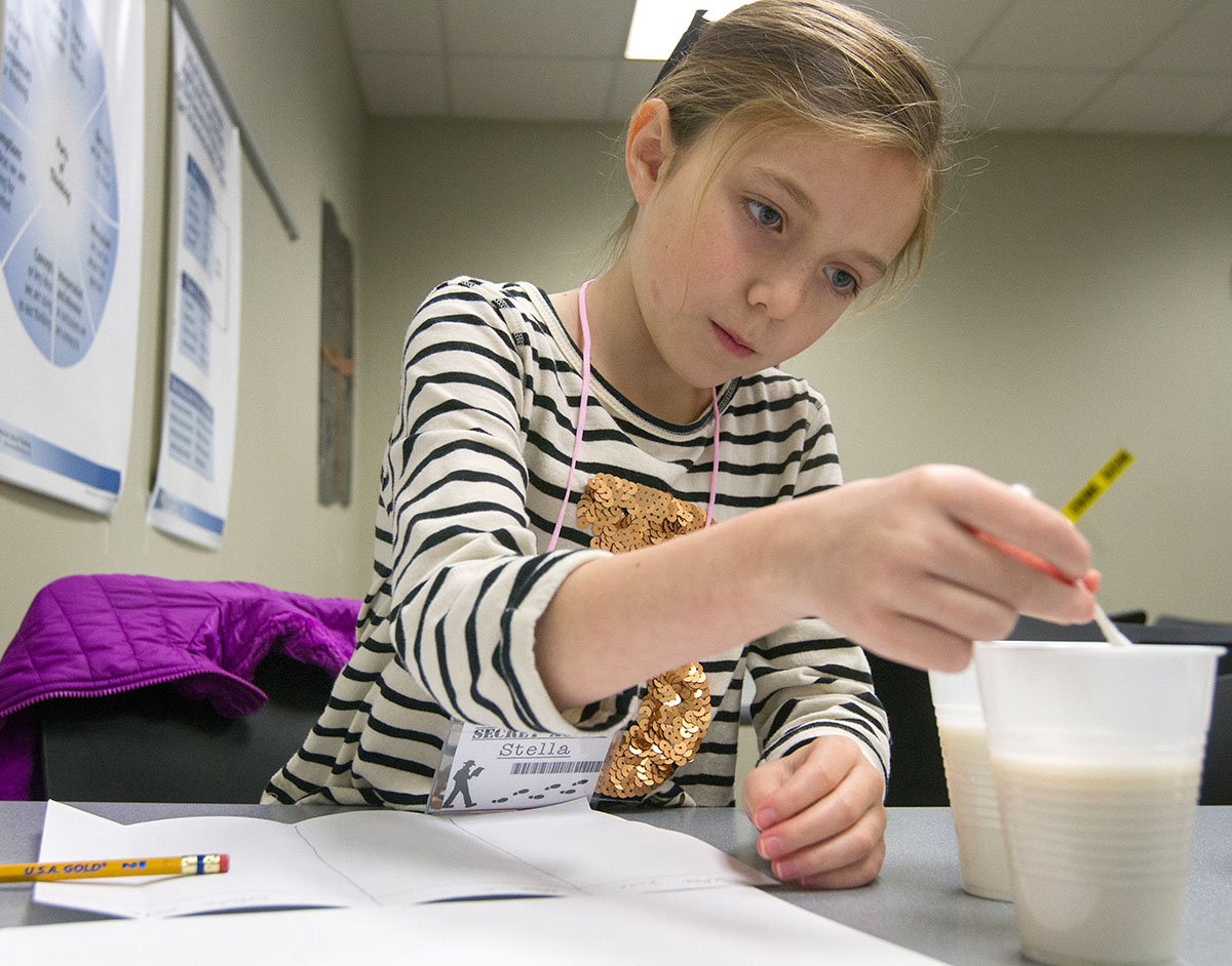 Stella Forney uses whole milk and almond milk to write hidden messages in CSI Jr. Detective Academy.