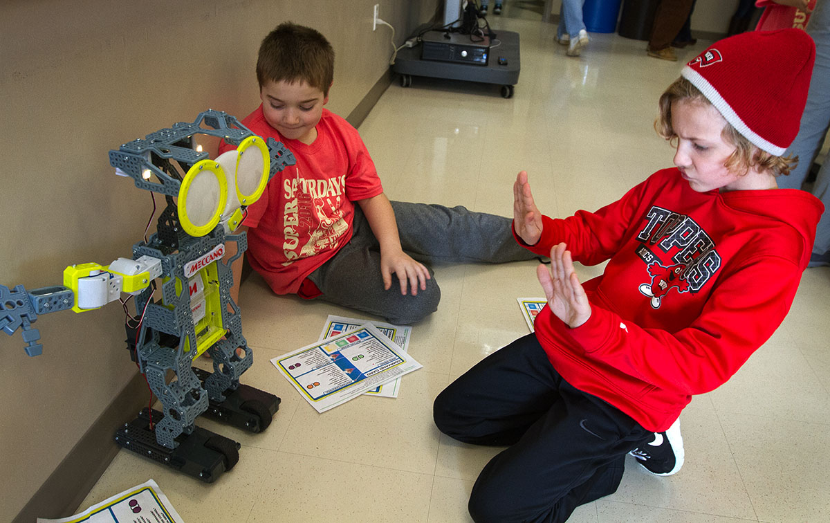 Cooper Jones dances with a robot he gave voice commands to in Behind the Scenes Movie Science.