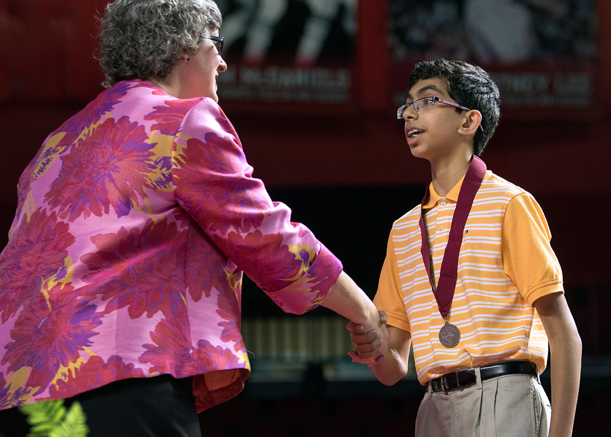 Gatton Academy Director Lynette Breedlove congratulates a seventh grader after presenting him with a medal.