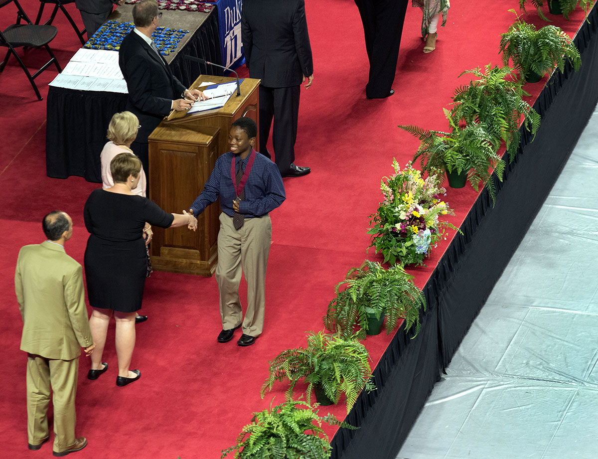 Leann Pickerell, the Kentucky Department of Education's gifted and talented consultant, congratulates a seventh grader after he received his medal.