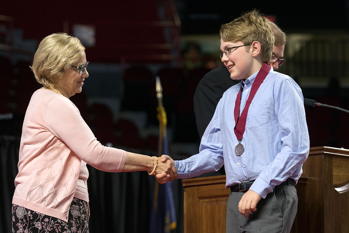 Julia Roberts, the executive director of The Center for Gifted Studies and The Gatton Academy, congratulates a seventh grader after he received his medal.