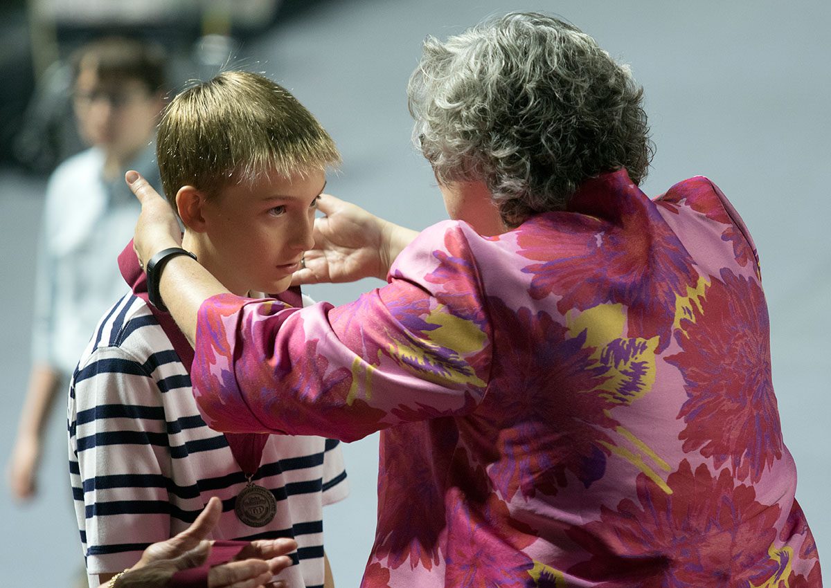 Gatton Academy Director Lynette Breedlove presents a seventh grader with his medal.