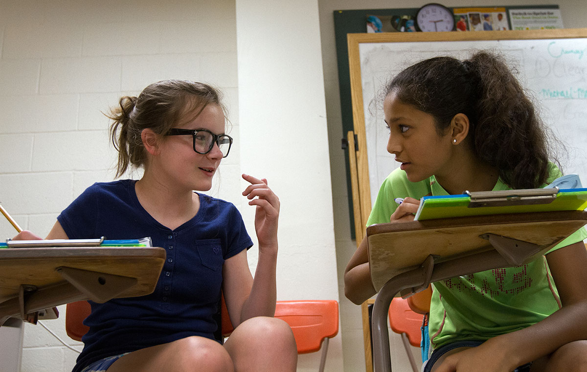 Emma McGuffey (left) and Alisha Pansuria, both from Bowling Green, discuss the stories they're writing during Writing Boot Camp Thursday, June 16. (Photo by Sam Oldenburg)