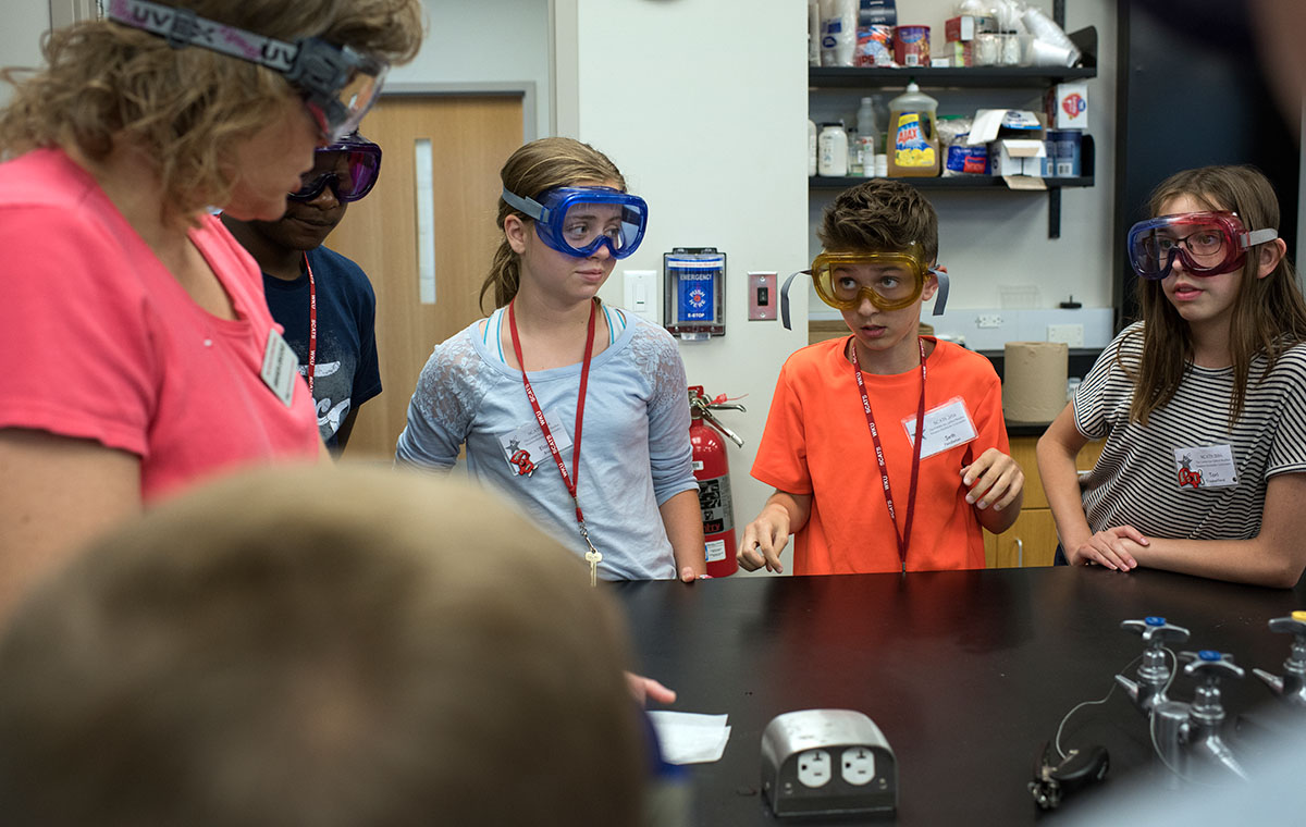 Seth Pendleton (middle) of Louisville asks Chemistry of Everyday teacher Amanda Brooks a question before the class begina a lab Wednesday, June 15. (Photo by Tucker Allen Covey)