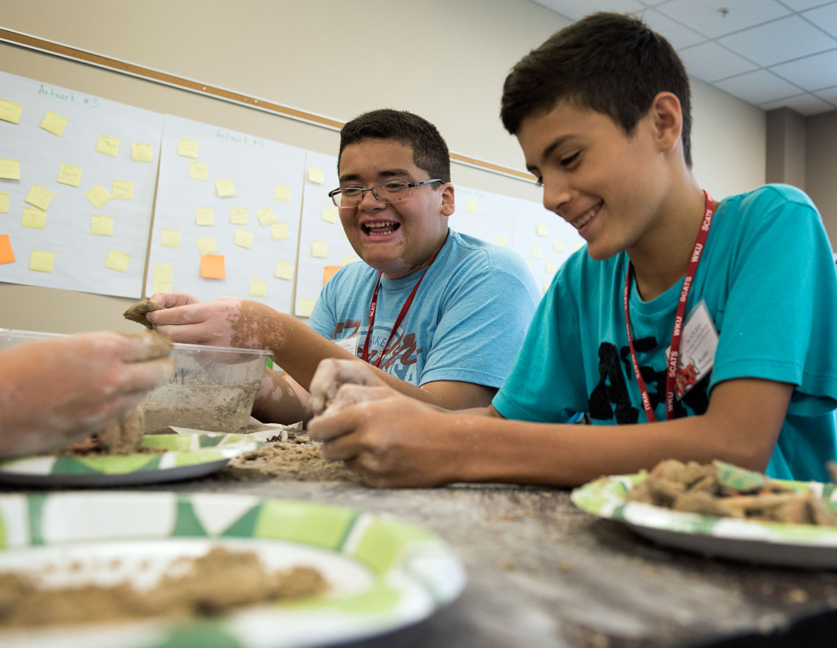 Javier Sierra (left) and Austin Wallace, both from Bowling Green, dig for artifacts buried in a mixture of plaster and play sand during Archaeology Thursday, June 16. (Photo by Tucker Allen Covey)
