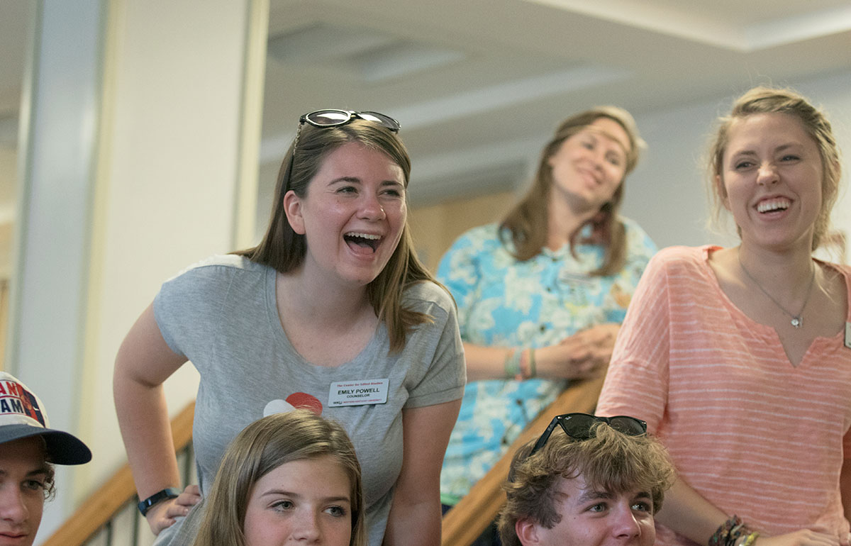 Counselors Emily Powell (left) and Ellie Hogg laugh while campers explain the dresses they created during the Say Maybe to the Frock optional Tuesday, June 28. (Photo by Sam Oldenburg)