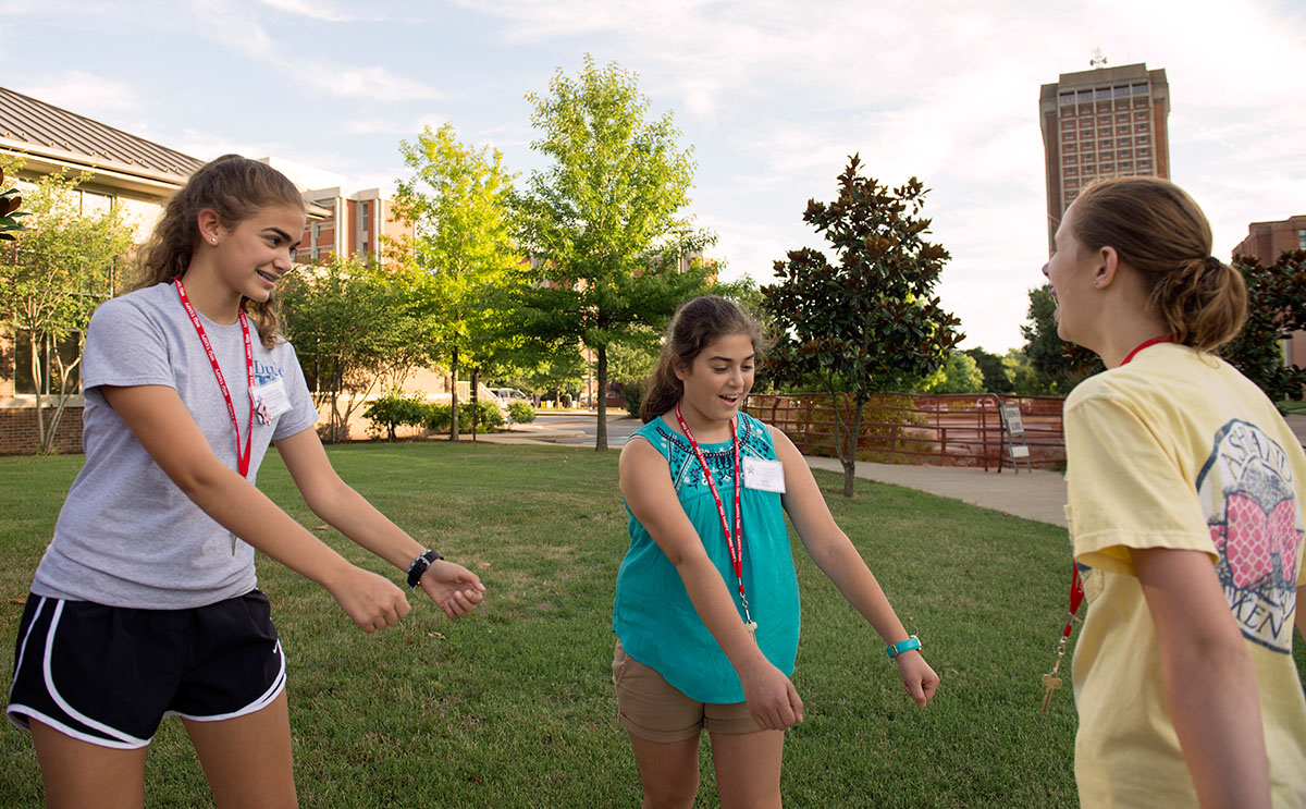 Sisters Maya (left) and Sara Abul-Khoudoud from Ashland,  dance with Sarah Baird from Russell to the music being played during the Software Parkour optional Wednesday, June 29. (Photo by Tucker Allen Covey)