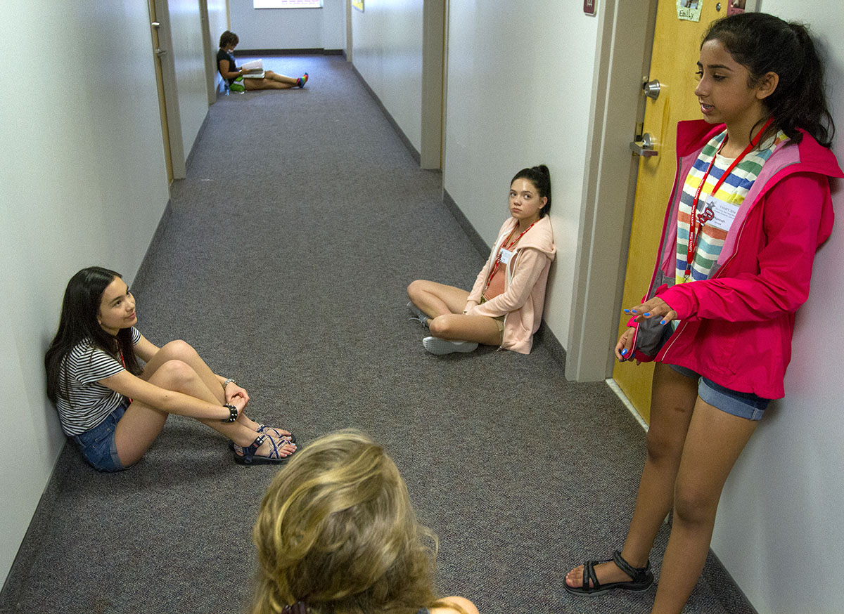 Sarah Pedersen (from left) of Barbourville, Emily Johnson of Louisville, and Hannah Jawed of Corbin discuss what they did in their first day of classes with their counselor, Ellie Hogg, before their hall meeting Monday, June 27. (Photo by Sam Oldenburg)