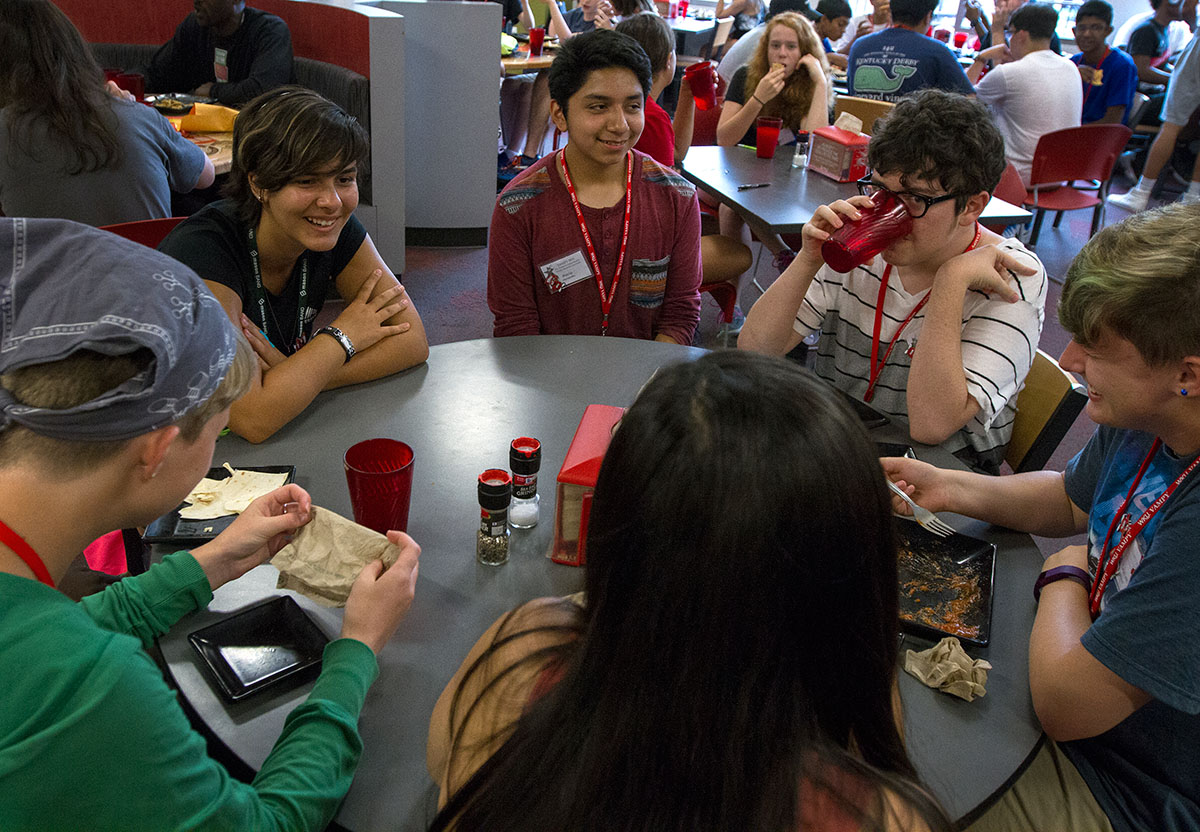 Lyd Cohron (top left) of Bowling Green, one of Ellie's campers, visits with other campers after eating dinner in Fresh Food Company inside the Downing Student Union Monday, June 27. (Photo by Sam Oldenburg)