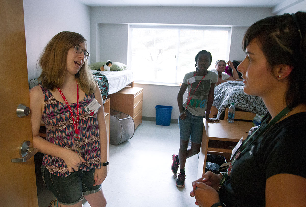 Tori Rhodus of Louisville holds her door open while visiting with several of her hallmates after dinner Monday, June 27. (Photo by Sam Oldenburg)