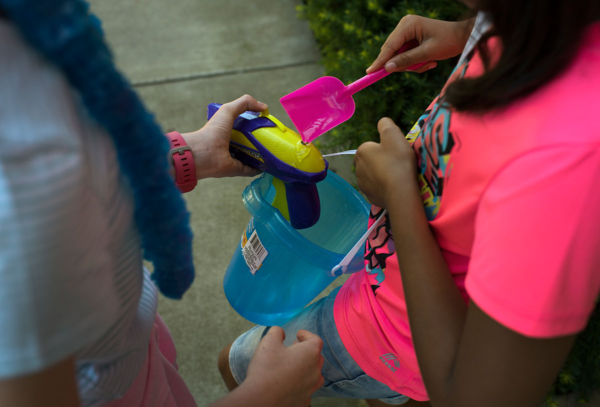 Kareena Pansuria (right) helps her classmate Ava Coffman refill her water gun for an experiment conducted during Math at day one of Camp Innovate on Monday, June 6. (Photo by Tucker Covey)